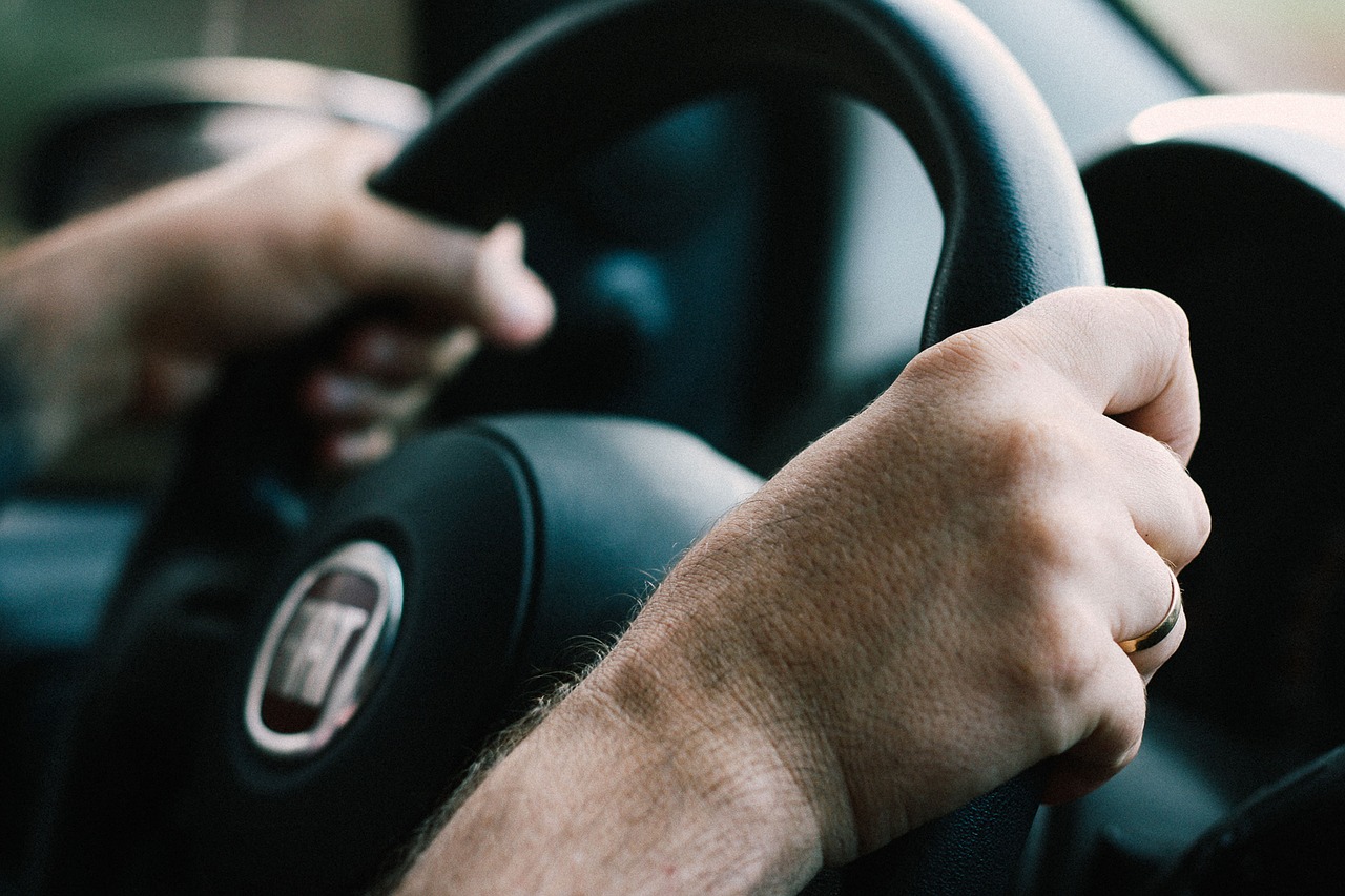 Adult hands on Car Steering Wheel