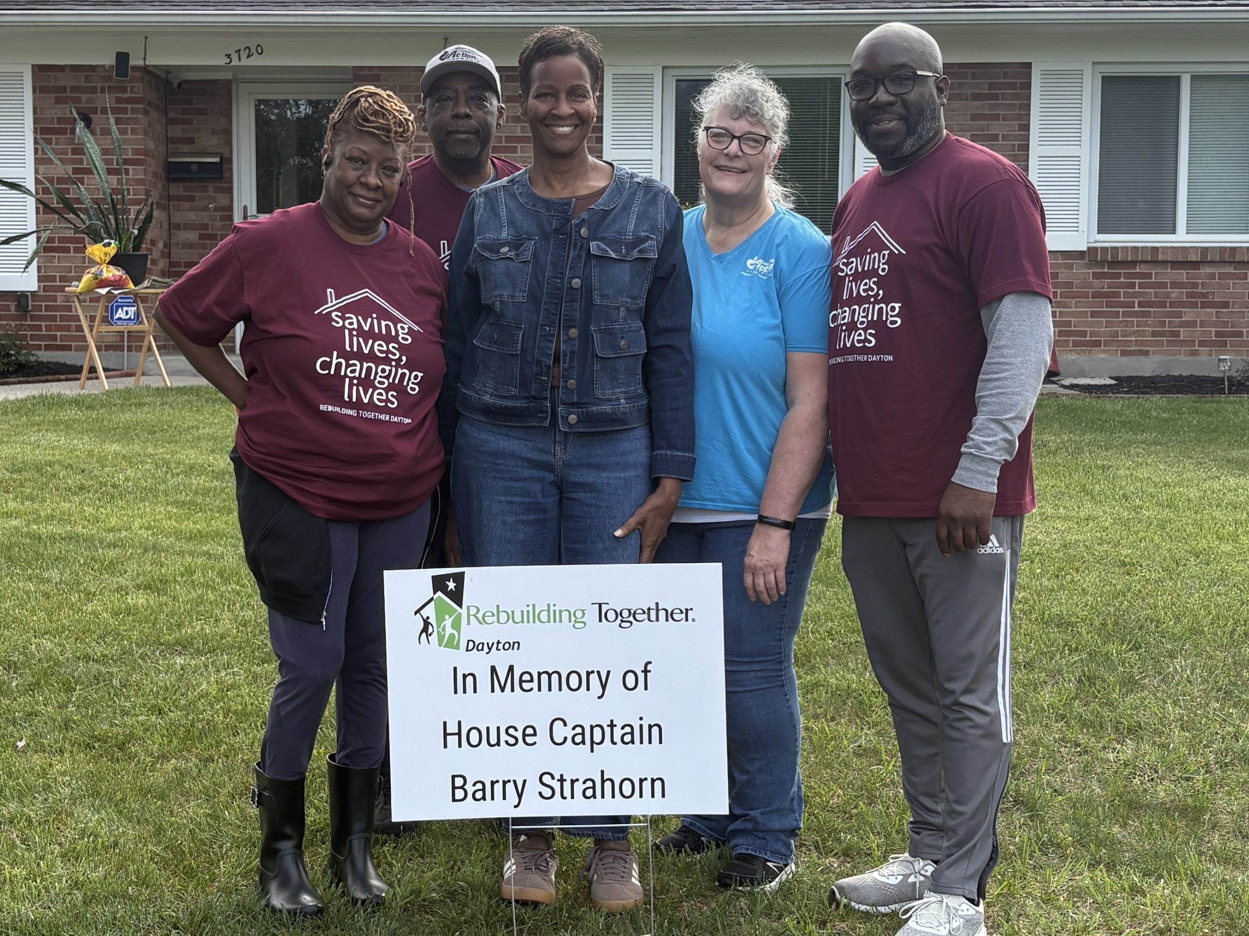 Group of people in front of a house honoring Barry Strahorn