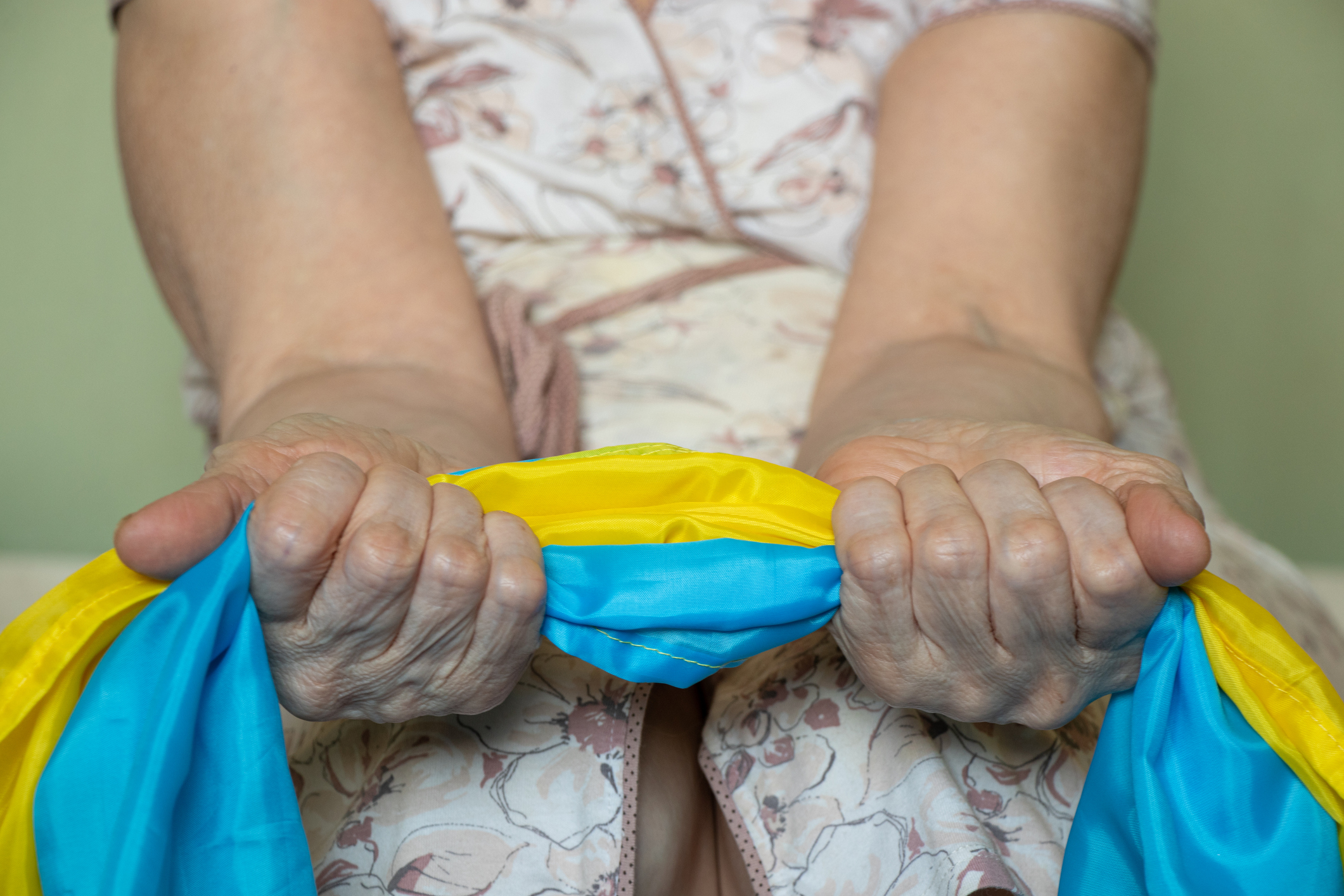 elderly woman holding ukranian flag