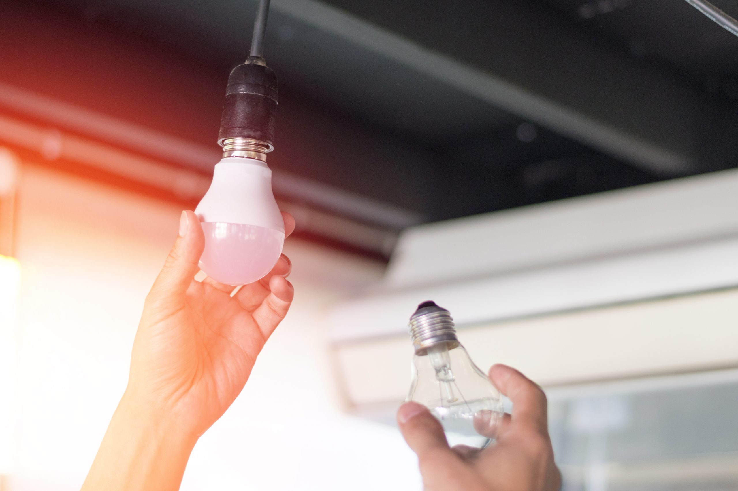 Hands changing a lightbulb to an energy efficient model